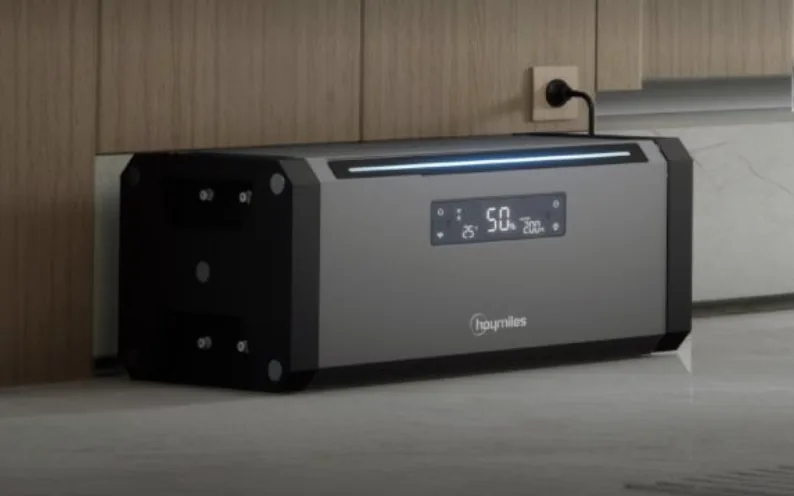 Hoymiles HiBattery 1920 AC steht im Wohnraum auf dem Boden, das Netzkabel steckt in der Wandsteckdose dahinter