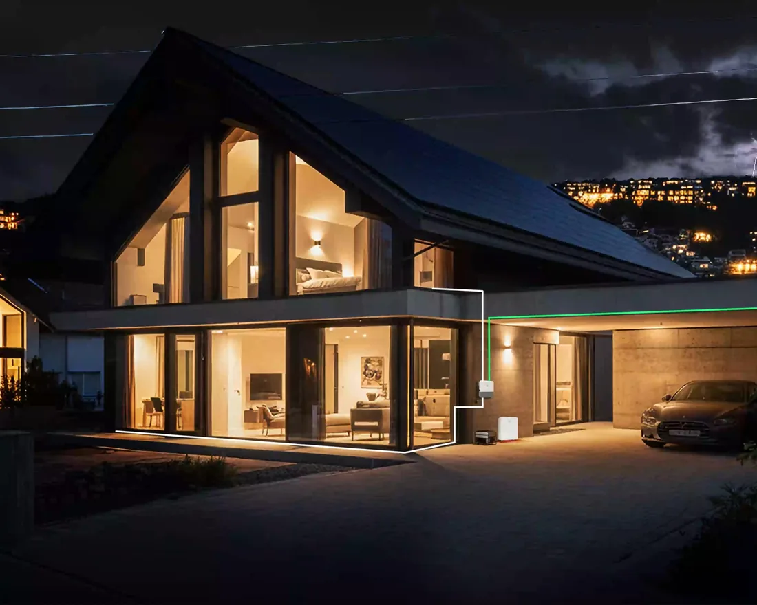 Beleuchtetes Einfamilienhaus bei Nacht und Gewitter, das Haus wird bei Netzausfall weiter versorgt