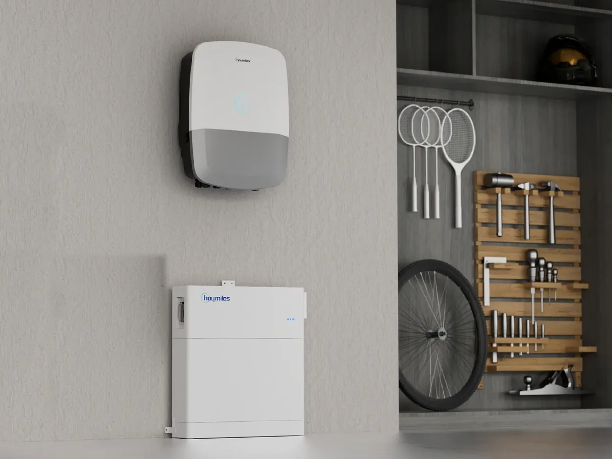 Hoymiles HIT-Wechselrichter mit LED-Ring an einer Garagenwand, darunter ein G2-Speicherturm aus PDU-Box, einem Batteriepack und Standfuß